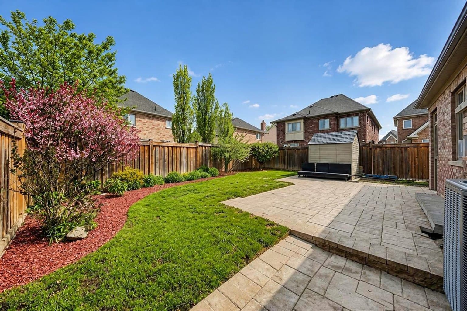 Backyard listing photo after AI furniture removal — umbrella & hoses cleared, room untouched