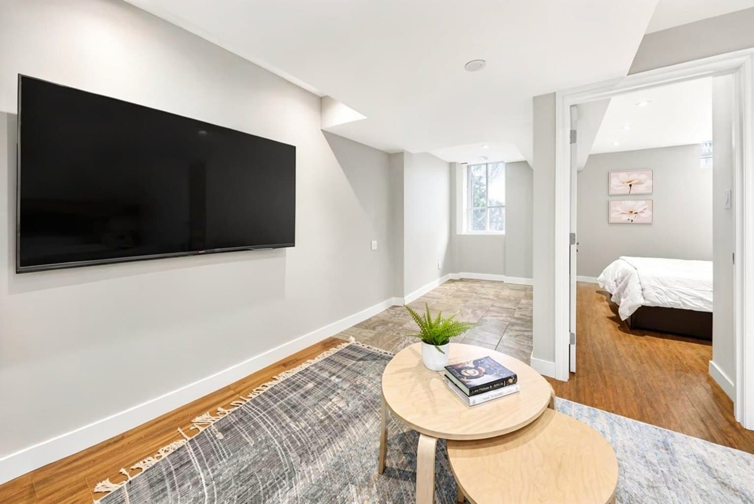 Basement Rec Room listing photo after AI furniture removal — media console & bookcases cleared, room untouched