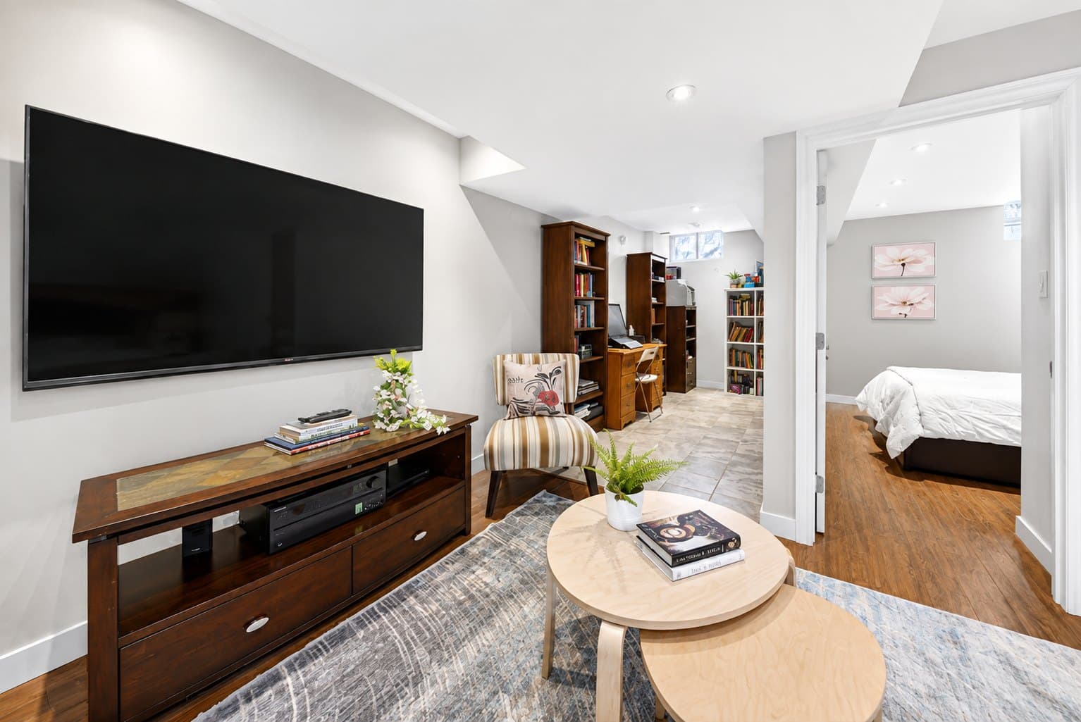 Basement Rec Room listing photo before AI furniture removal — media console & bookcases still in the room