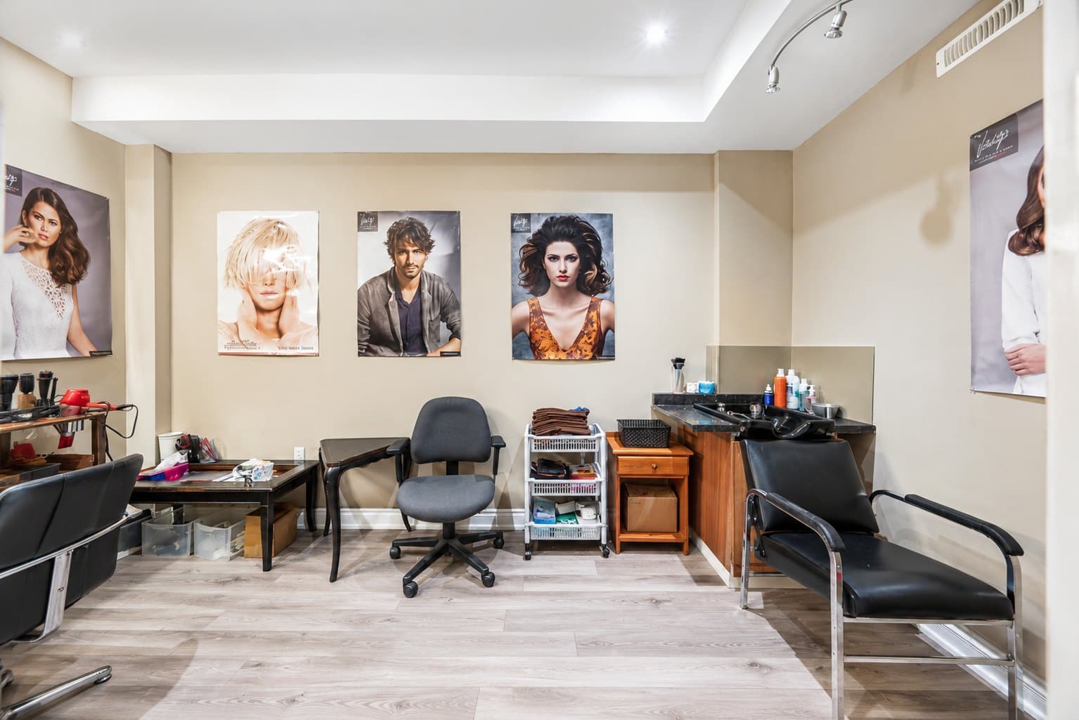 Basement Salon listing photo before AI furniture removal — salon chairs & stations still in the room