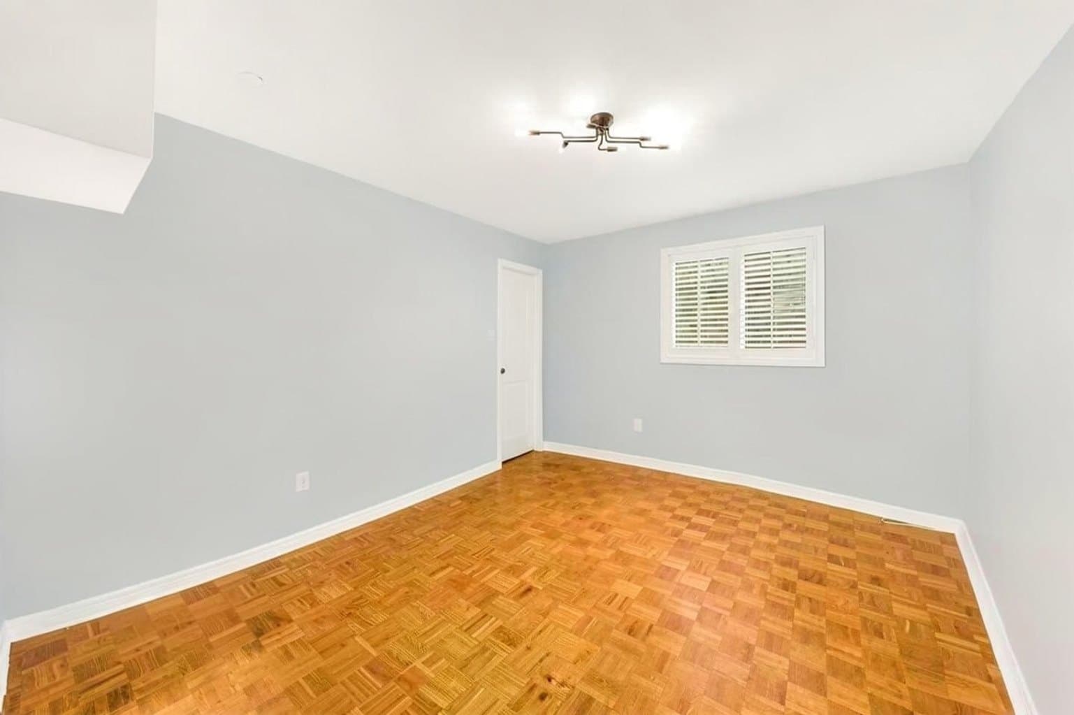 Bedroom listing photo after AI furniture removal — bed, desk & shelving cleared, room untouched