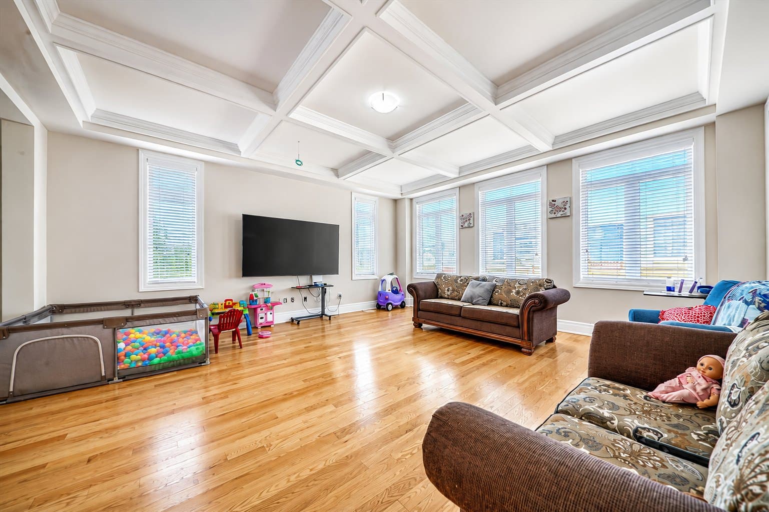 Living Room listing photo before AI furniture removal — toys & playpen still in the room
