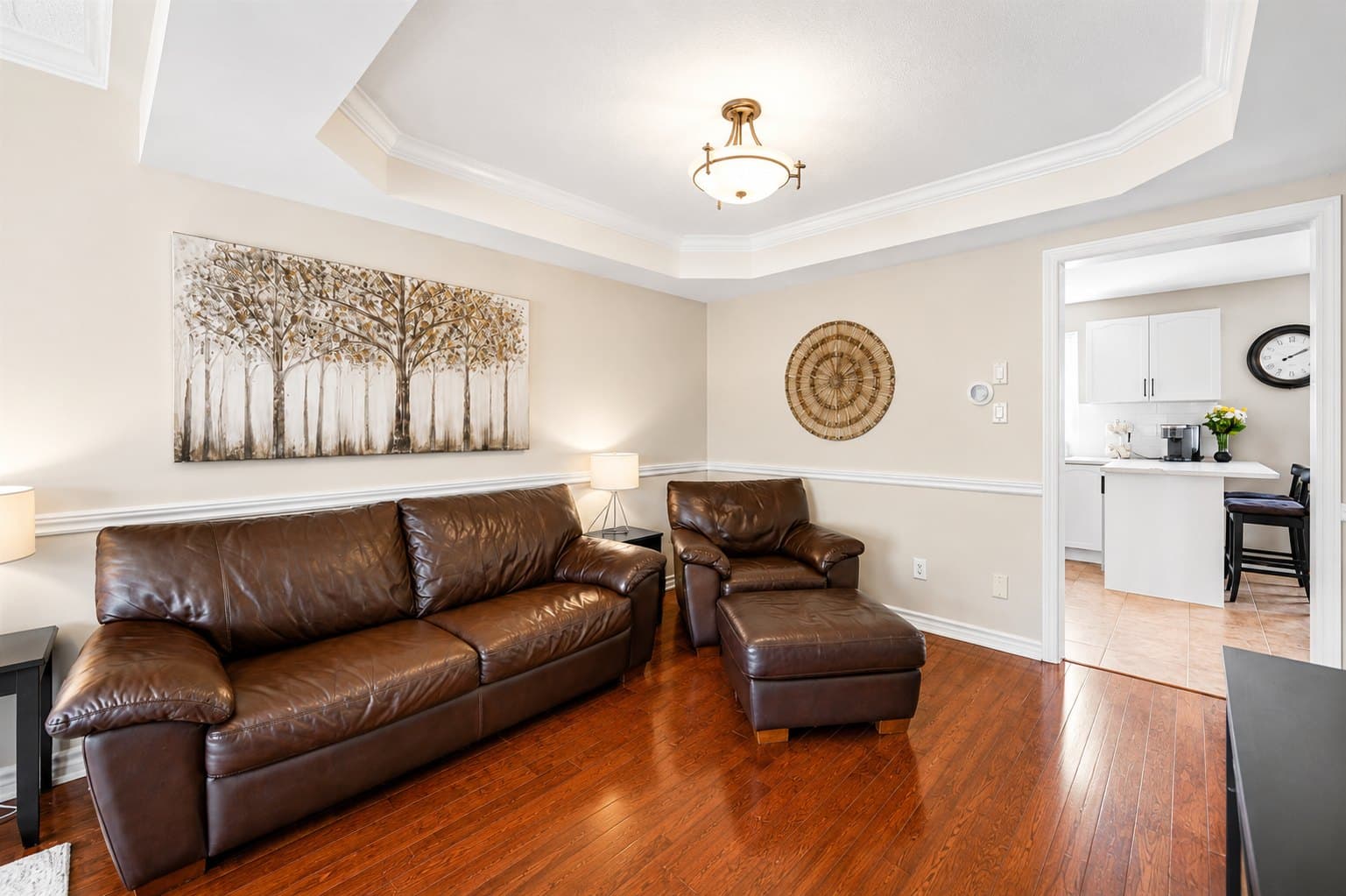 Living Room listing photo before AI furniture removal — armchair, ottoman & lamps still in the room